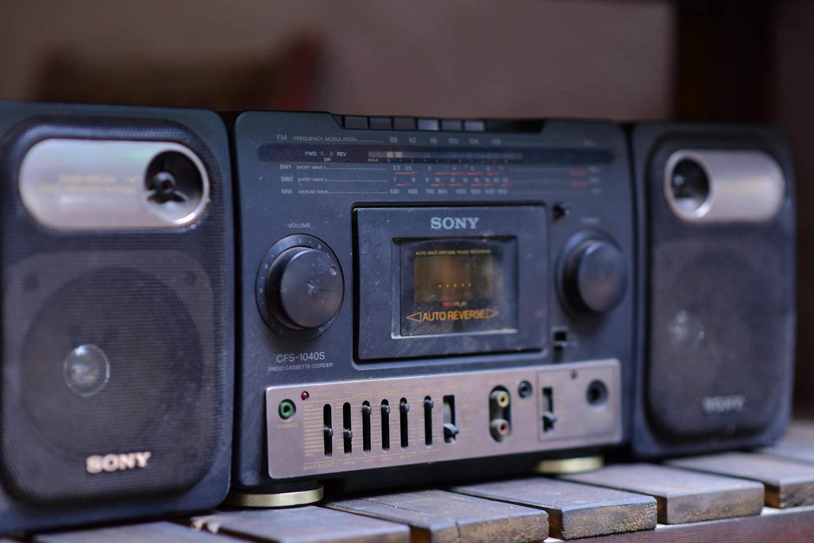 Close-up of a vintage Sony boombox cassette player with speakers on a wooden surface.